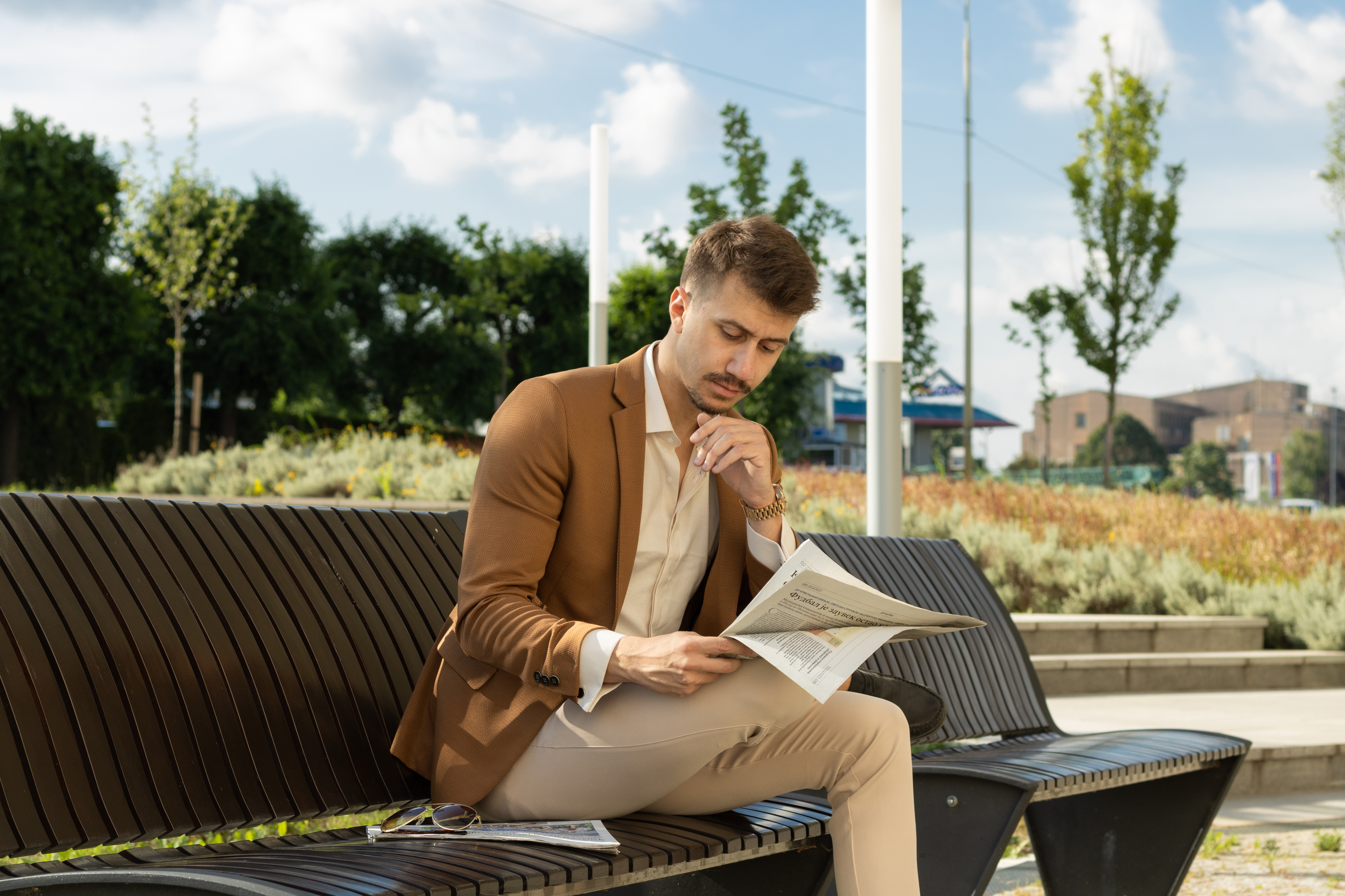 Man sitting on a bench in a park, reading a newspaper, by Vojislav Zivkovic aka Vojke Photo